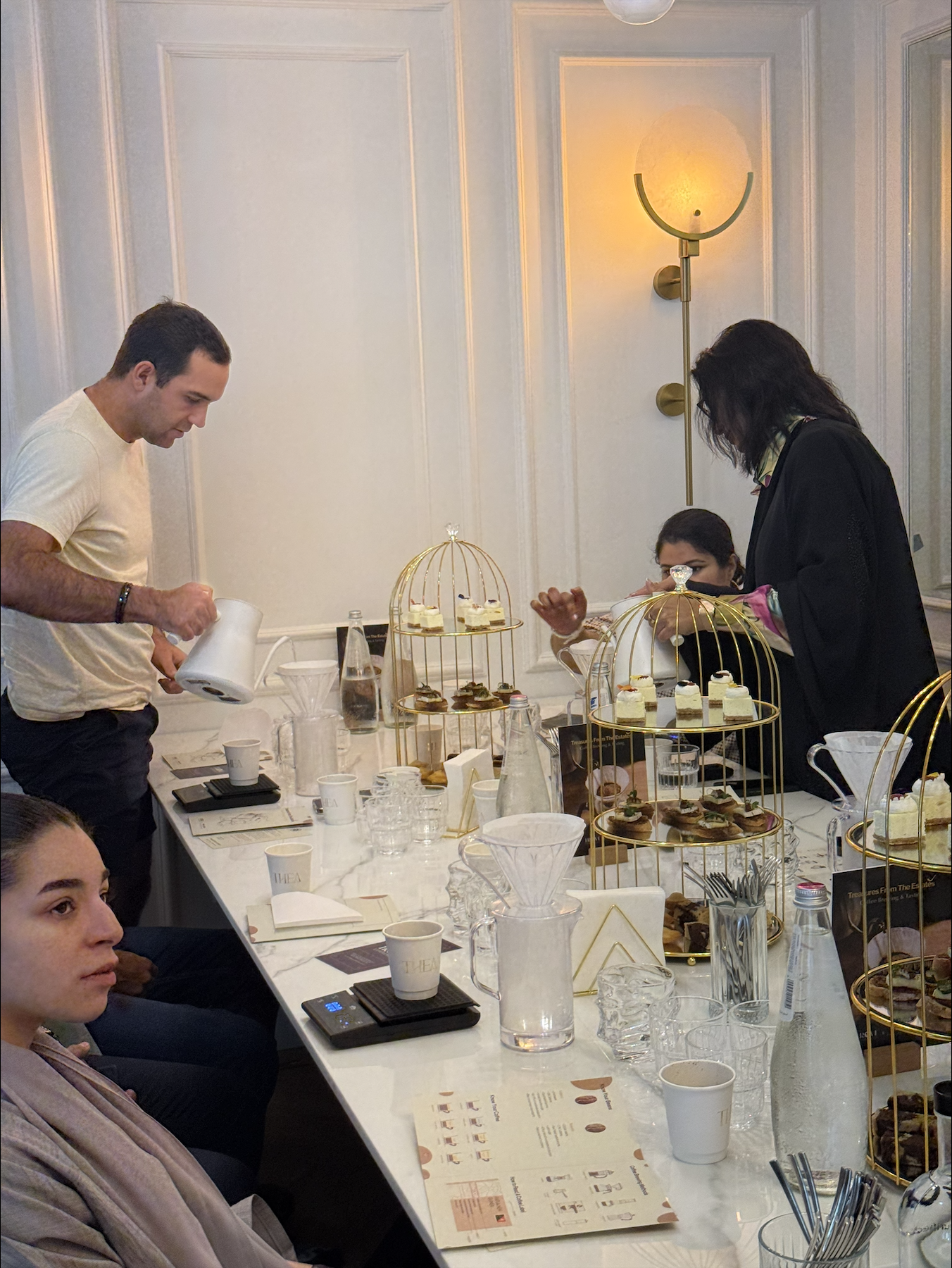 Workshop participants brewing coffee with V60 pour-over sets alongside Maryam Tabatabaei at the Farm to Cup coffee workshop